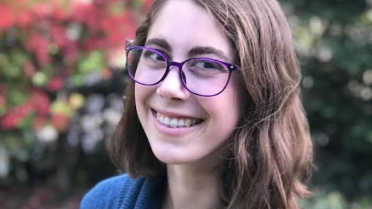 Headshot of Amber Ellis in a blue turtleneck smiling