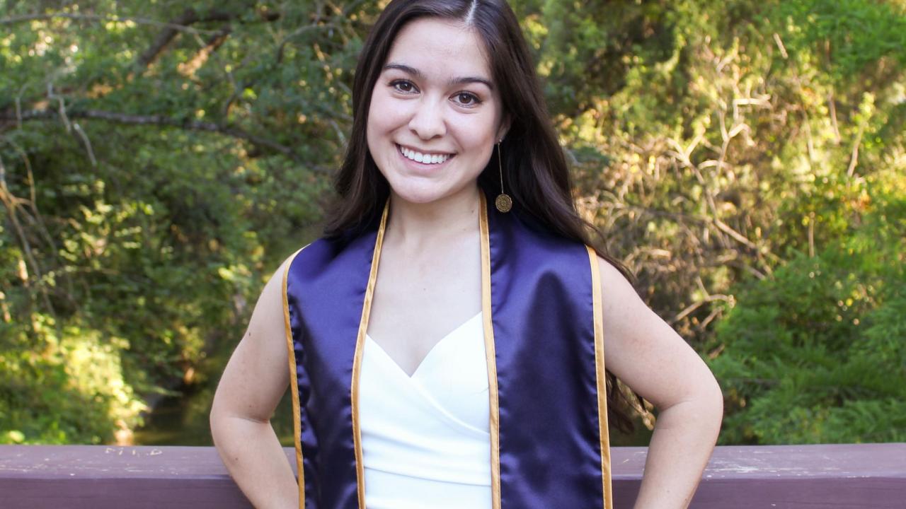 Claire Chapman smiling with graduation stole