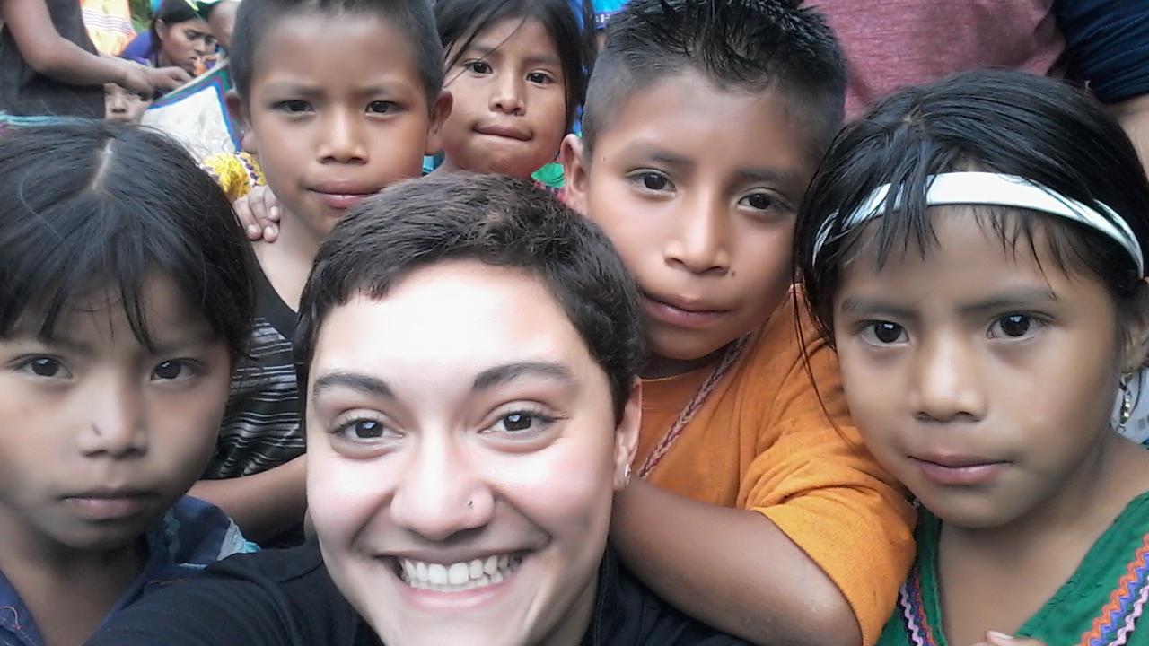 Sarai and many children smiling at the camera