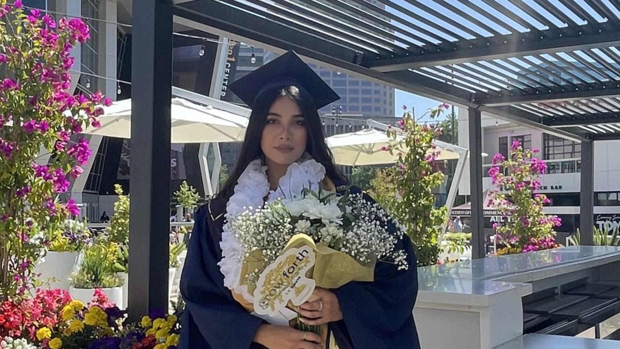 Anita holding flowers, celebrating UC Davis Graduation