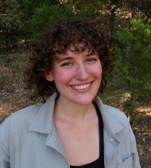 emily smiling standing in front of trees and bushes