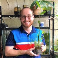 Aaron R. Milanese holding a plant